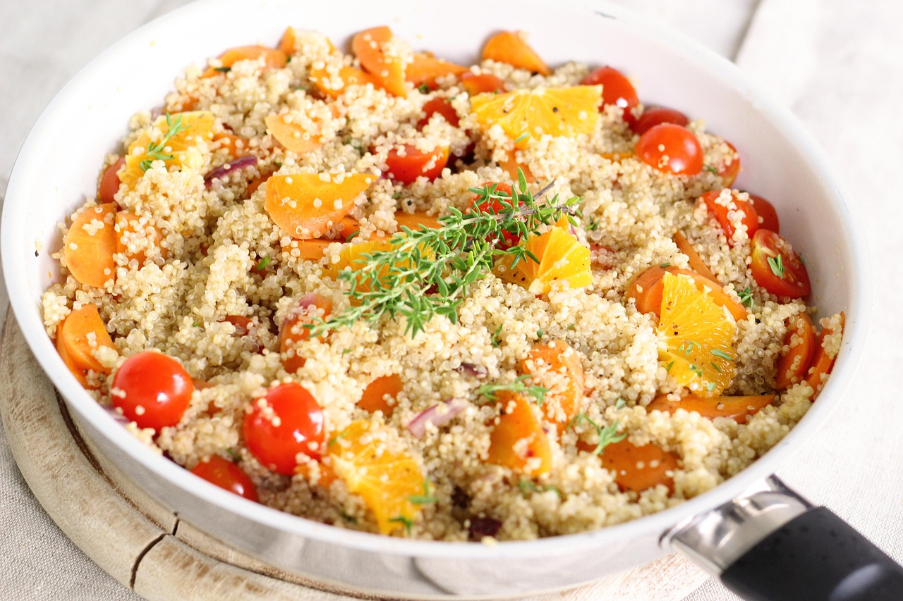 Quinoa cotta in una casseruola con verdure fresche e spezie.