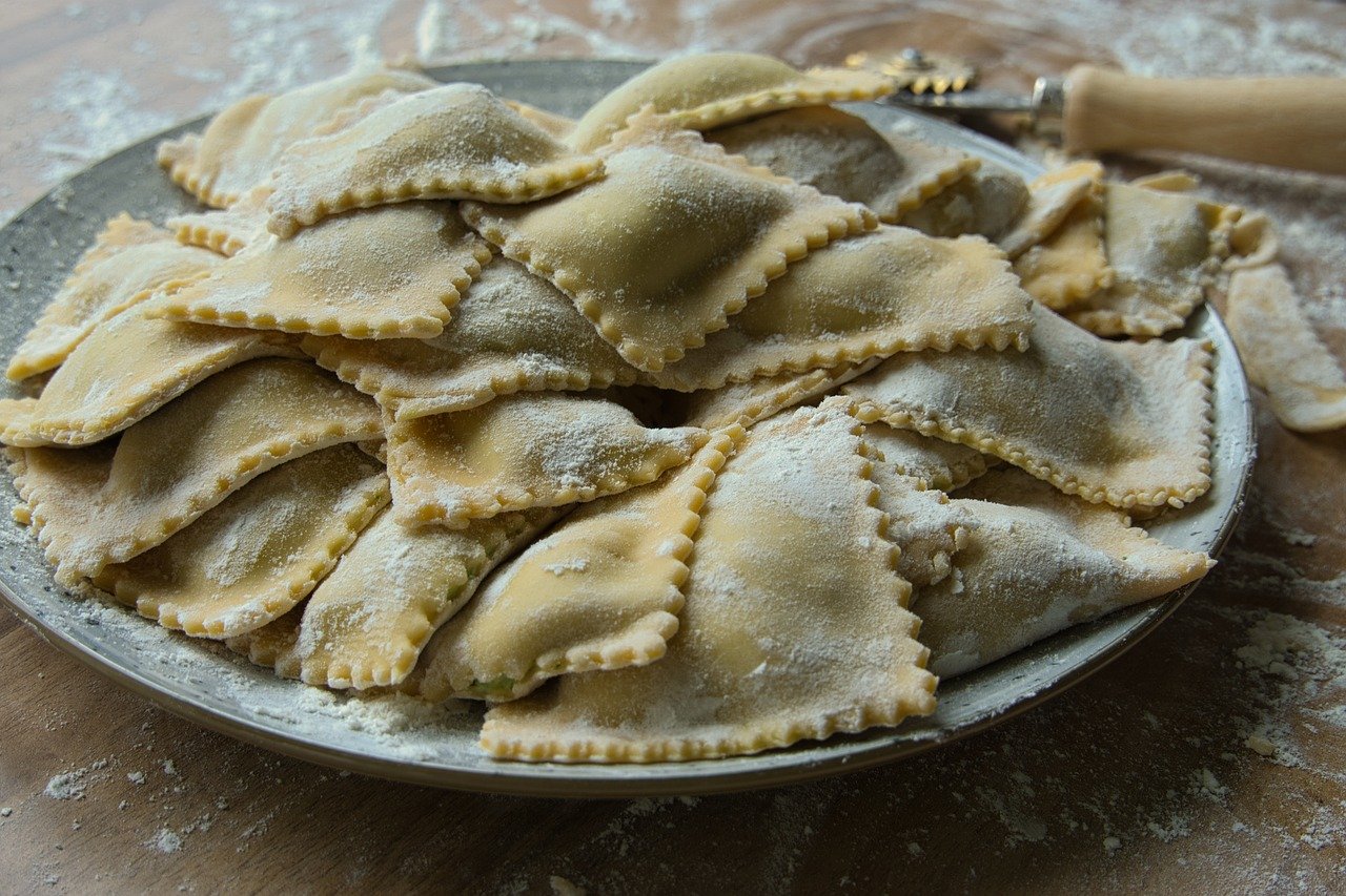 Ravioli freschi con ripieno cremoso su un piano di lavoro, pronti per essere cucinati.