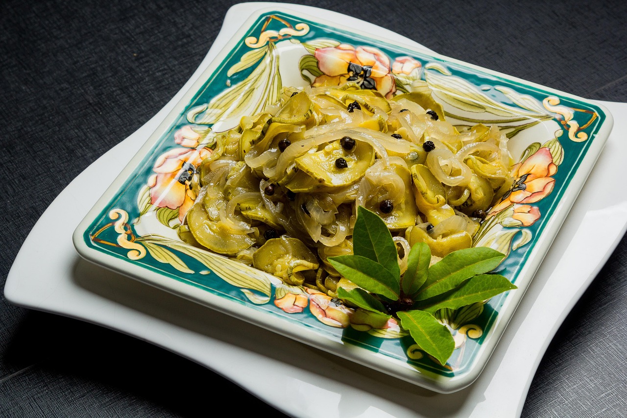 Zucchine alla scapece napoletane pronte, condite con aceto e menta, servite su un piatto.