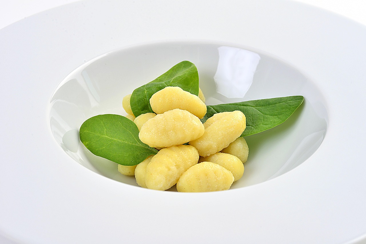 Gnocchi senza patate pronti da servire, morbidi e conditi con salsa.