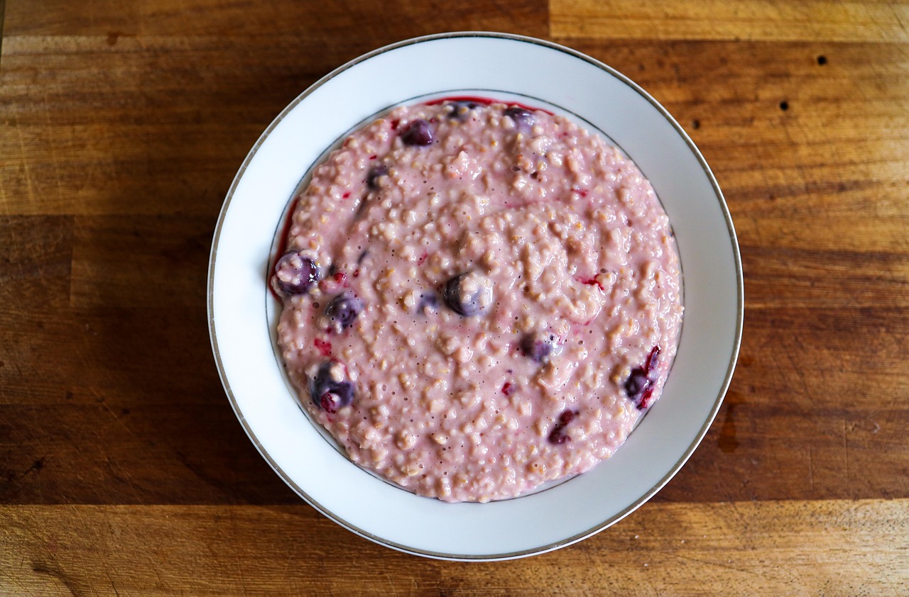 Porridge d'avena pronto per colazione, servito in una ciotola con frutta fresca e noci.